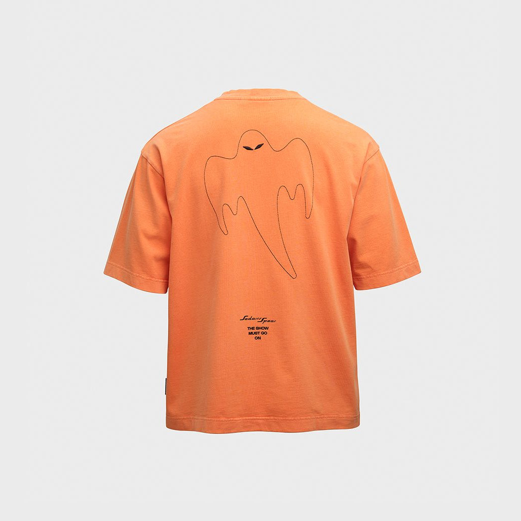 An orange short-sleeve t-shirt shown from the back, featuring a minimalist black line art graphic of a ghost and small text near the bottom, displayed on a light gray background.