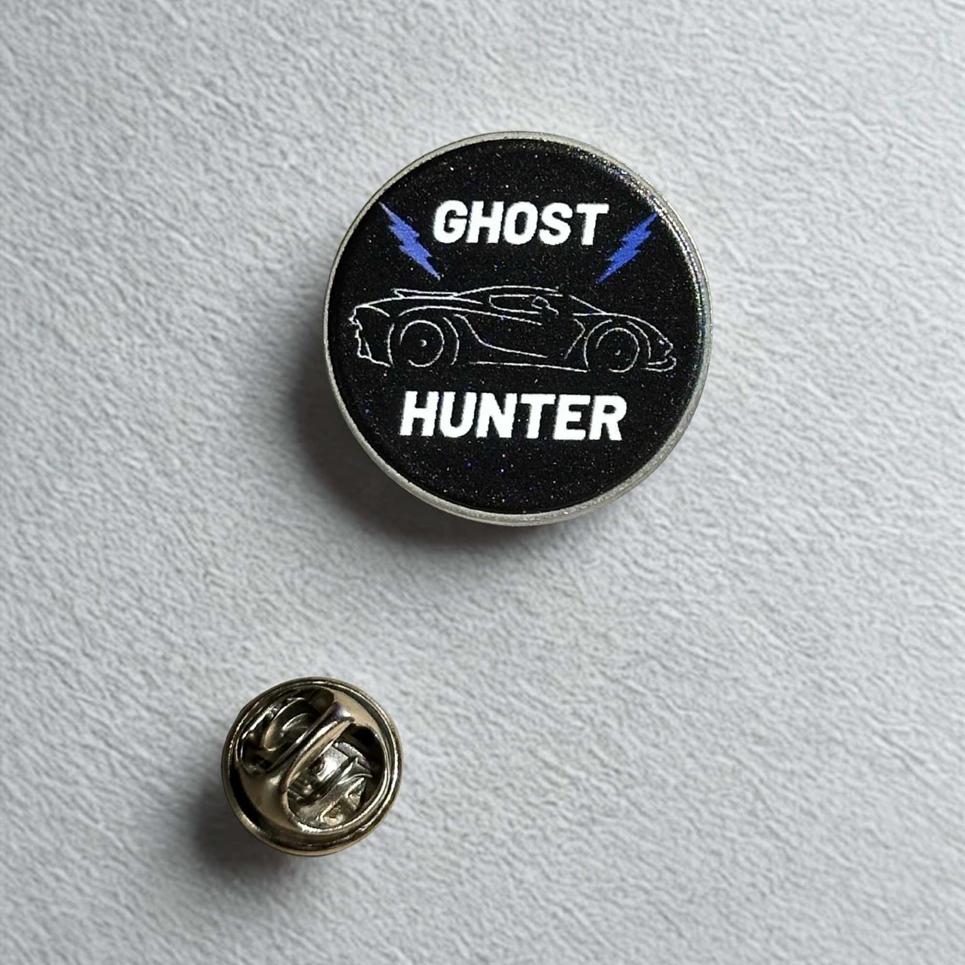 black pin badge with ghost hunter type in white