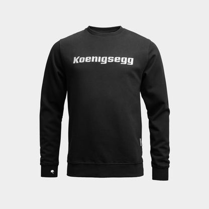 A black long-sleeve crewneck sweatshirt with 'Koenigsegg' printed in white across the chest, displayed on a light gray background.