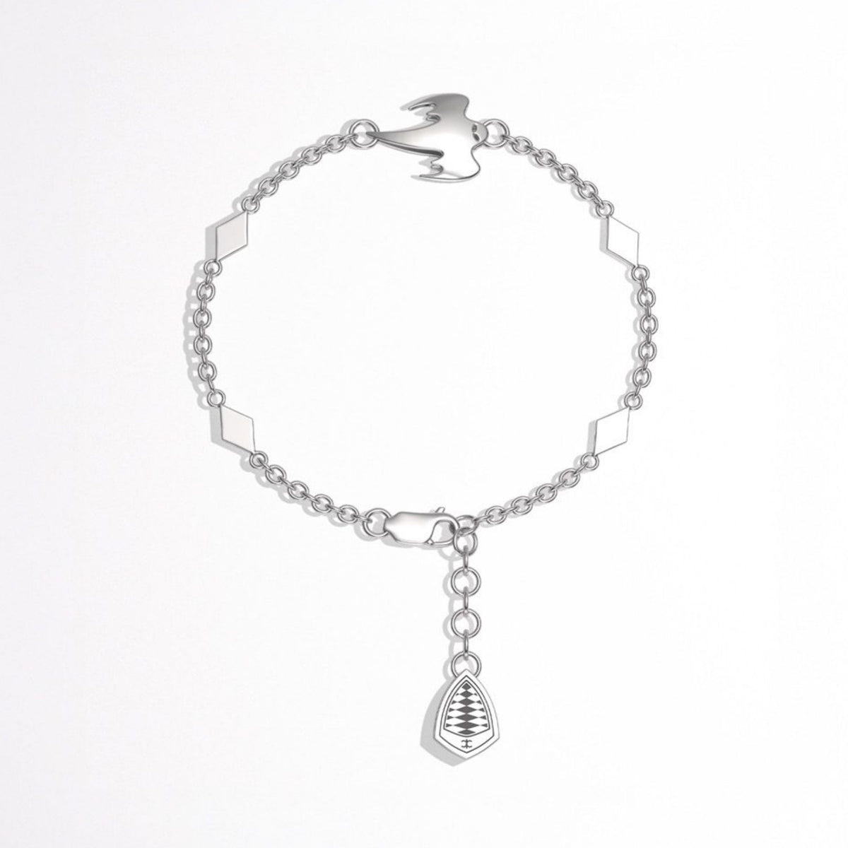 A silver chain bracelet with geometric diamond-shaped links, a ghost charm, and a dangling Koenigsegg crest charm, shown on a plain white background.