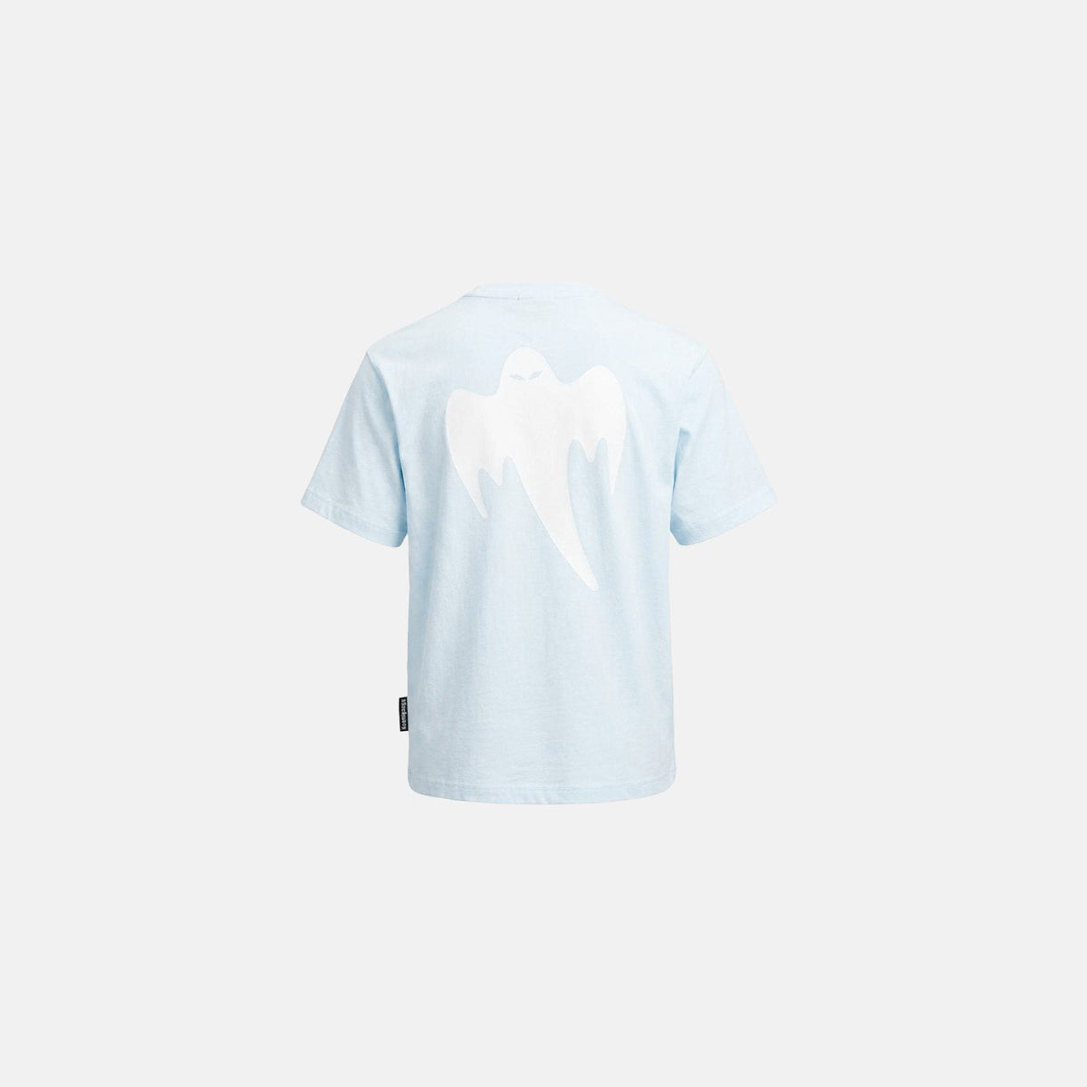 A light blue short-sleeve t-shirt shown from the back, featuring a large white ghost graphic and a small black brand tag near the bottom left hem, set against a solid off-white background.
