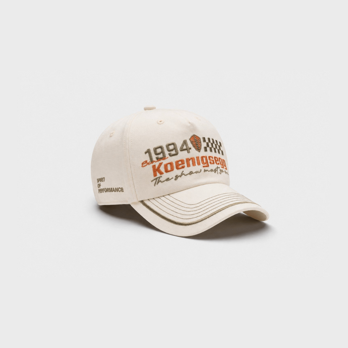 A beige baseball cap featuring '1994 Koenigsegg' embroidered on the front, set against a light gray background.