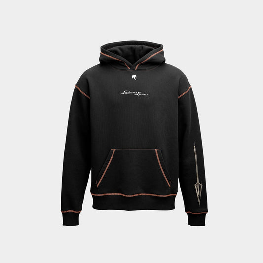 A black pullover hoodie with contrasting orange stitching, featuring a white script logo on the chest and a graphic on the right sleeve, displayed against a light gray background.
