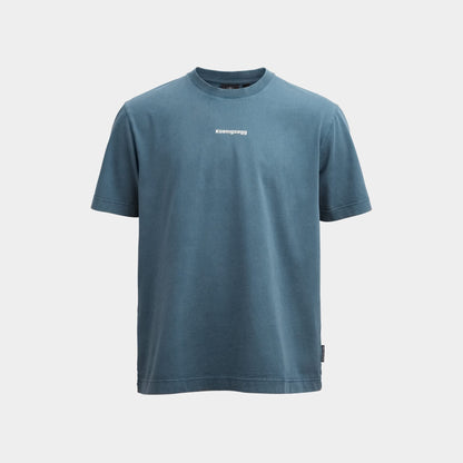 A slate blue short-sleeve crewneck t-shirt with a small white 'Koenigsegg' logo printed on the center chest, displayed against a light gray background.