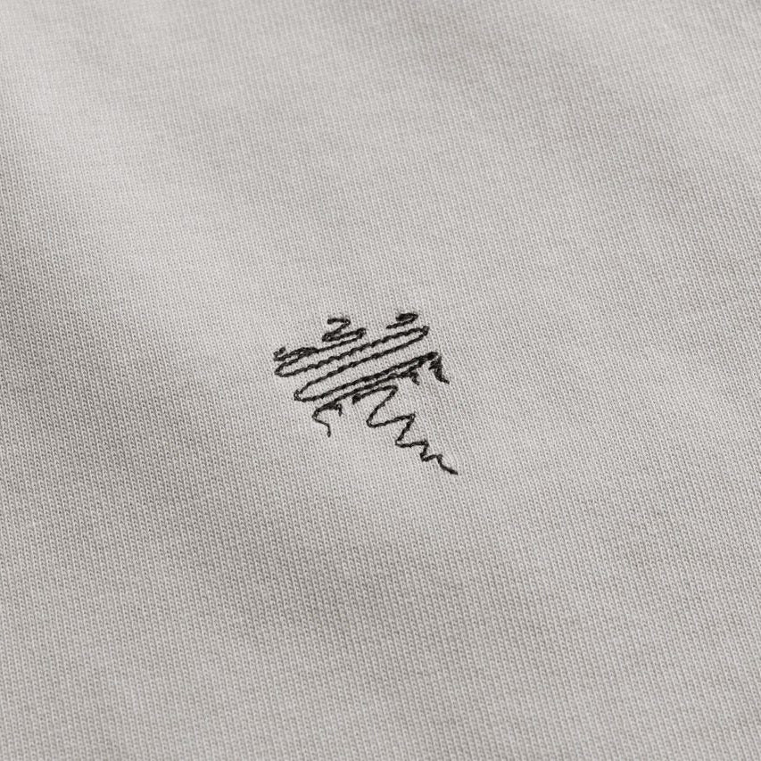 Close-up of a logo on a gray fabric surface